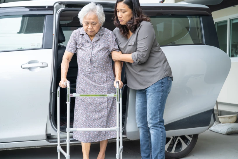 عکس از کمک کردن پرستار زمانی که سالمند از خانه خارج شده.
