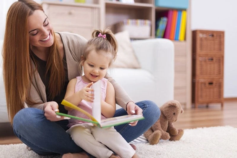 مادر در کتابخواندن به کودک کمک میکند
